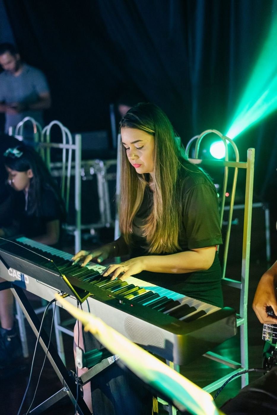 Aluna tocando teclado em apresentação